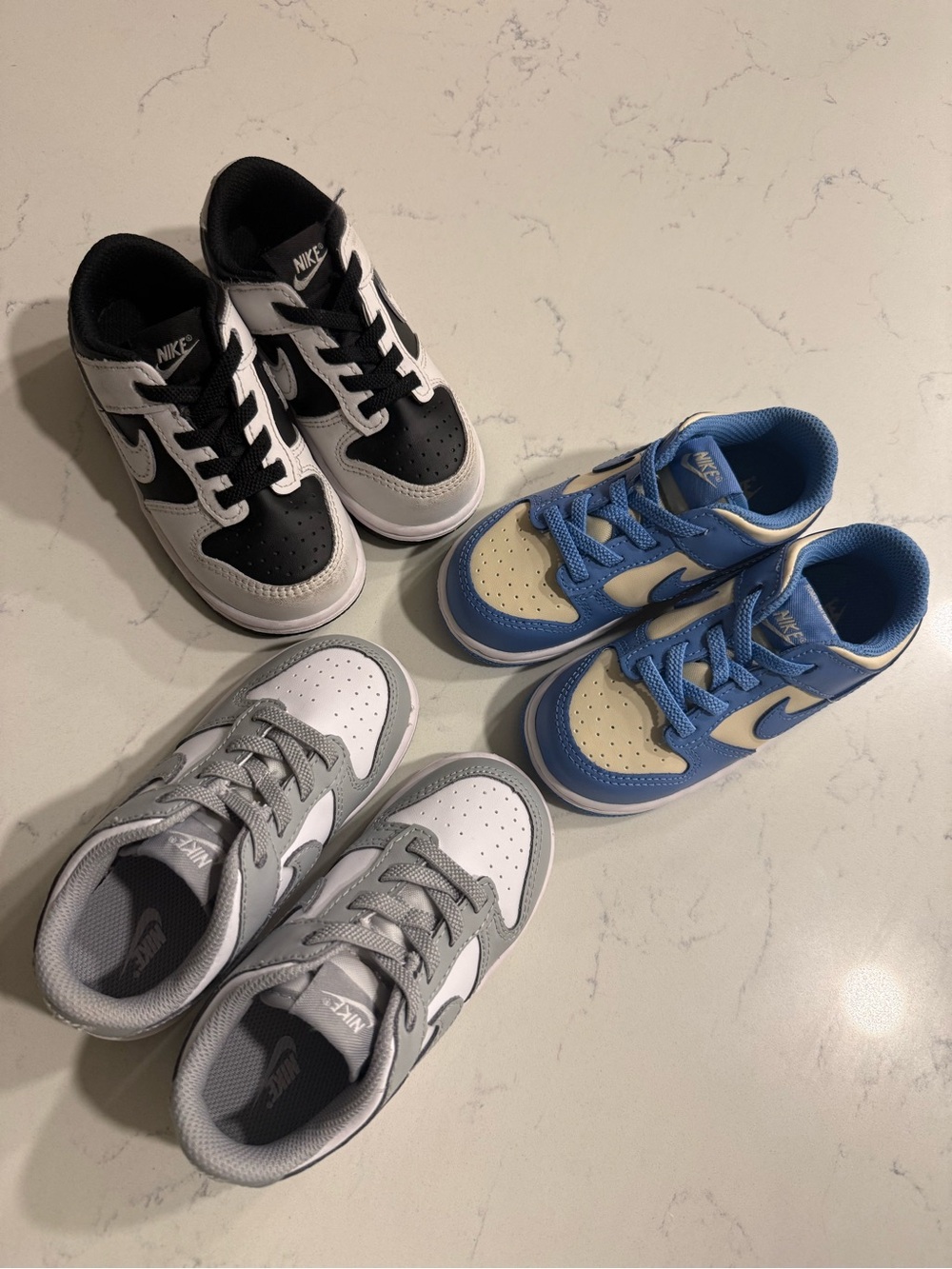 Nike Kids Low-Top Sneakers in Black/White, Blue/Cream, and Gray/White